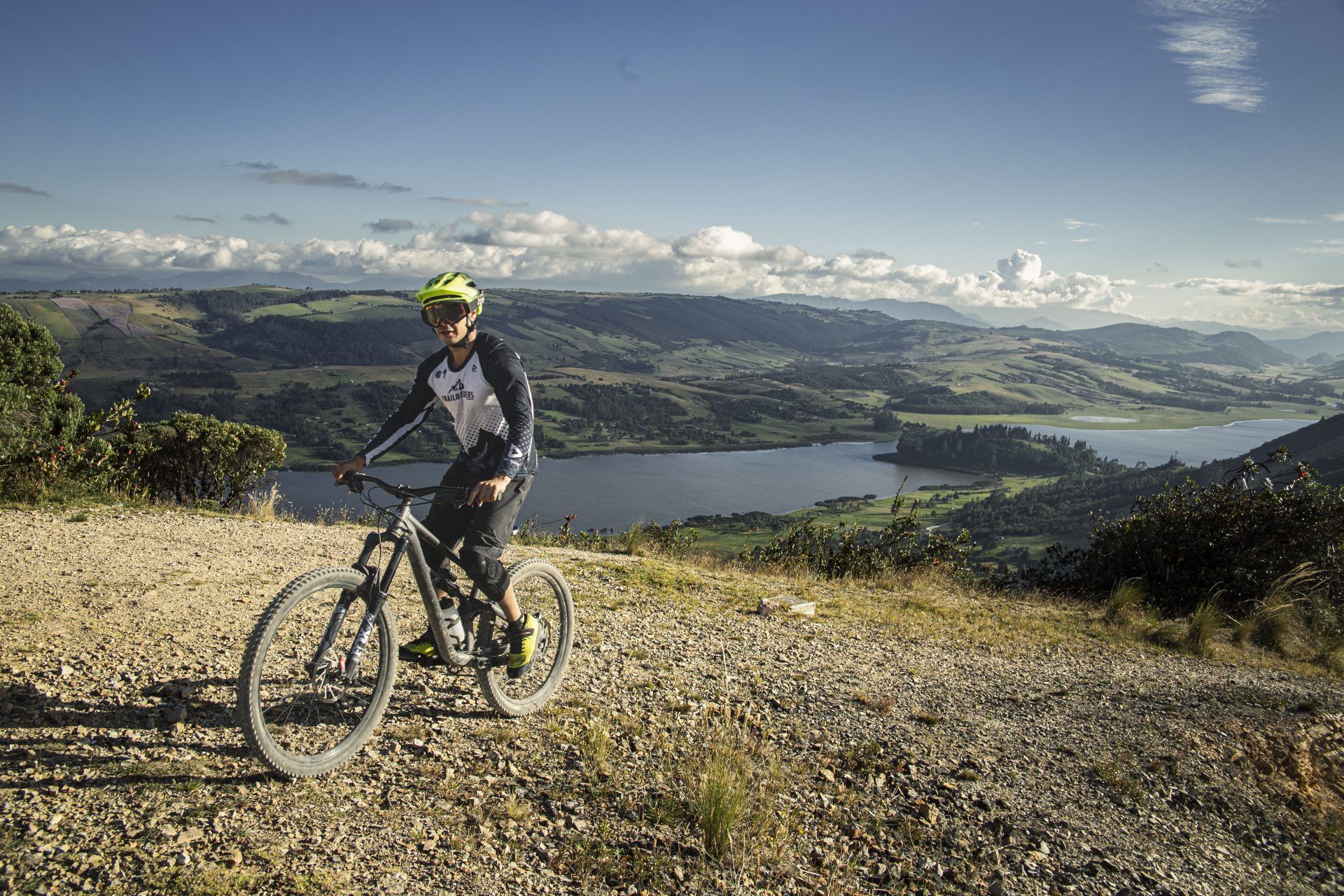 Mountain biker on a ridge trail above a valley and reservoir near Cucunubá, Cundinamarca
