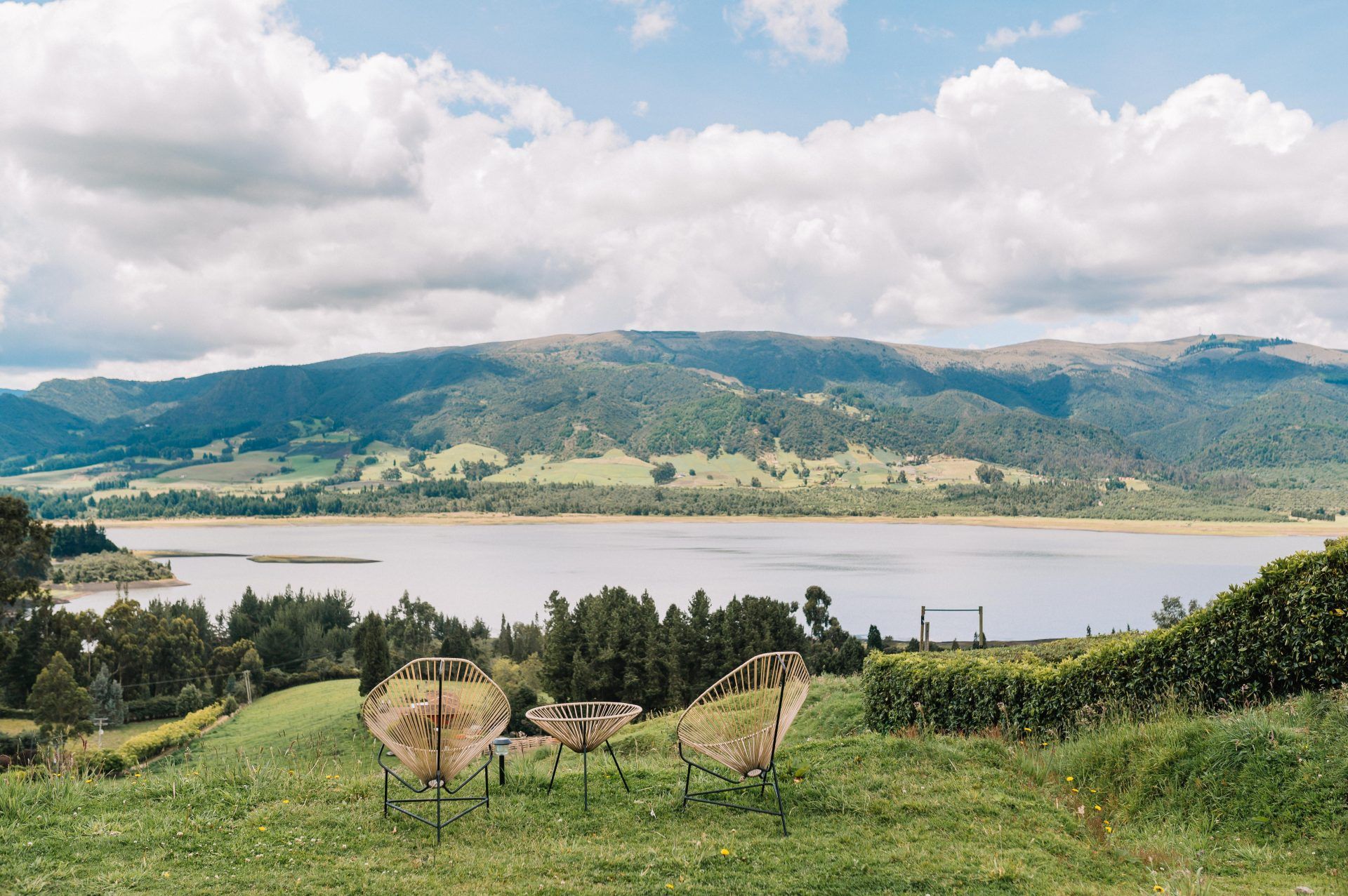 Lounge chairs on the lawn at Neusa Hills looking over the Neusa reservoir and the hills beyond
