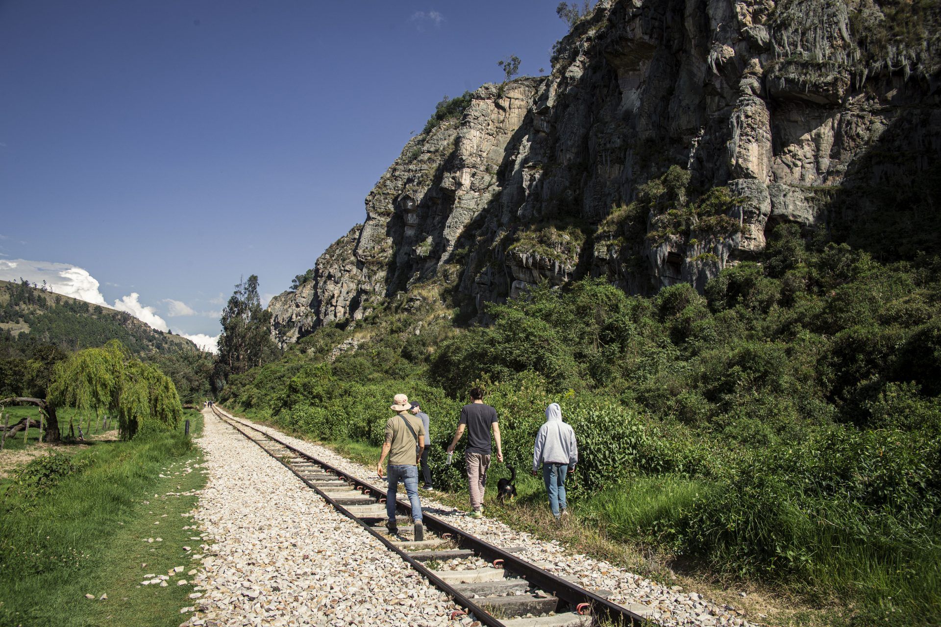 Walkers on the old railway line below the sandstone rocks of Suesca